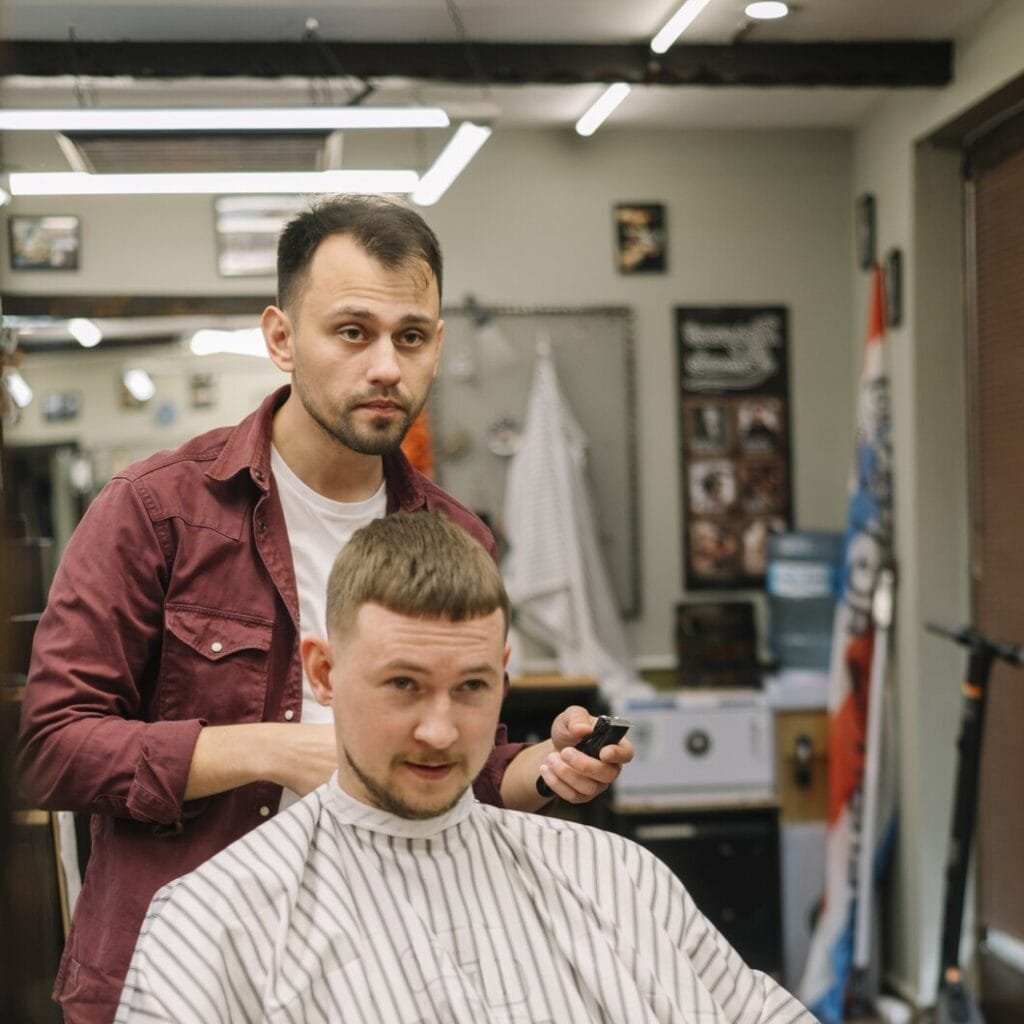 front-view-man-getting-haircut_23-2148506227